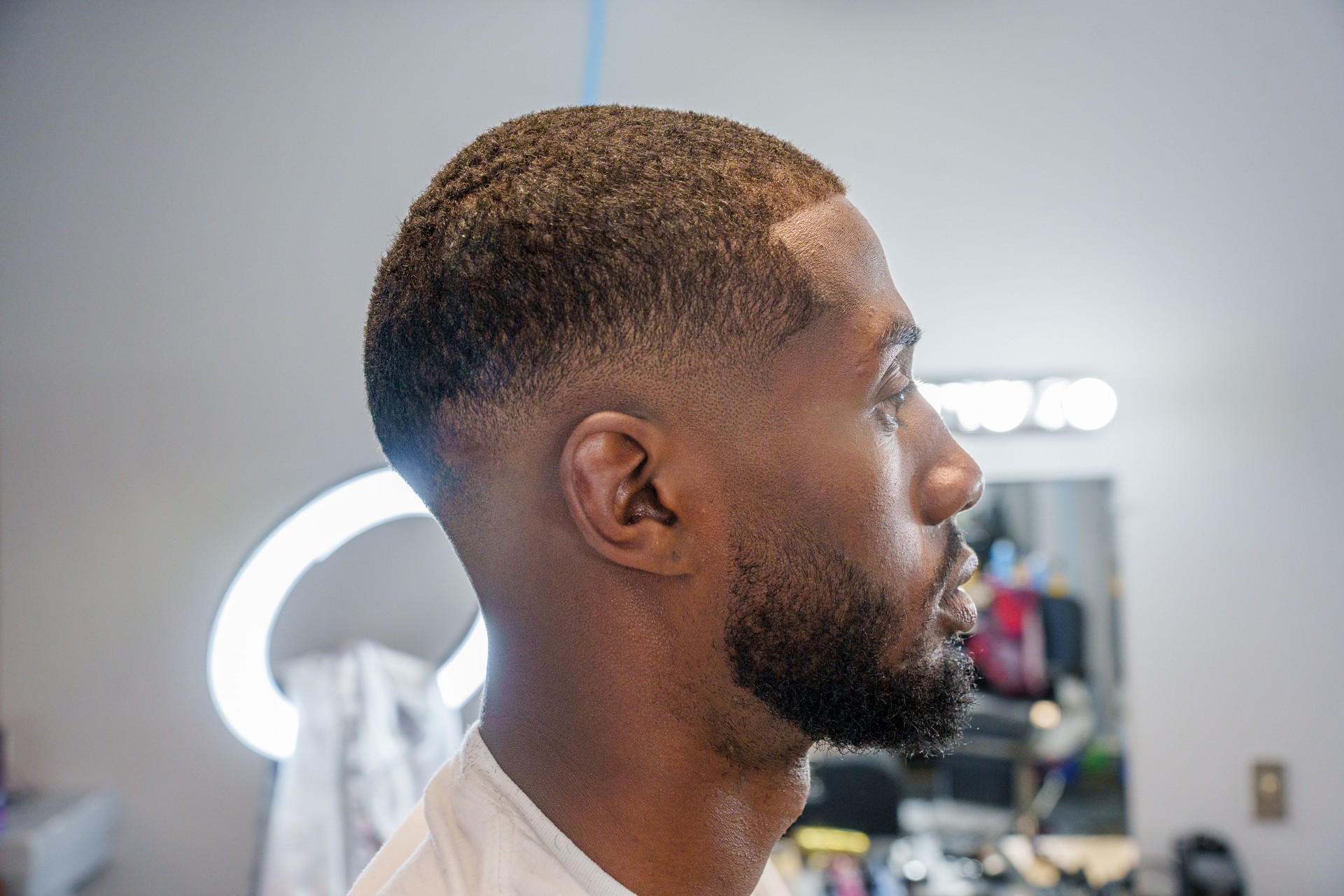 Young African American Man Receiving Fade Haircut from Mexican Barber in an Old Fashioned Barbershop with Electric Clippers